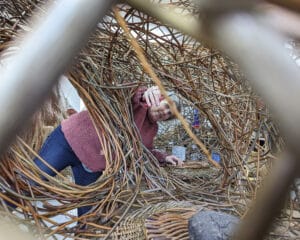 Julie Gurr, Willow Weaver, making Hawkes Architecture's entry, The dogs, for Goodwoof's, Barkitecture at Goodwood in May 2023.